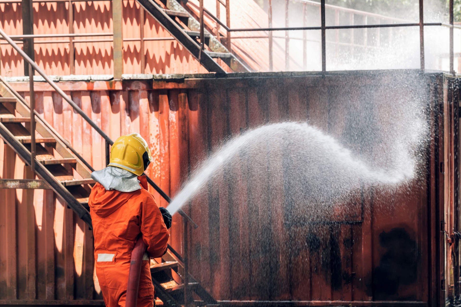 Firefighter Concept. Several firefighters go offensive for a fire attack. Fireman using water and extinguisher to fighting with fire flame.